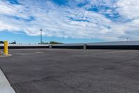 a parking lot with many storage containers under a cloudy blue sky by the docks area