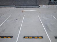 parking spaces outside with white lines and yellow arrows on the ground and brick wall and building