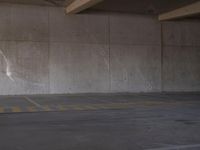 parking spaces with parking permit sign in city parking lot area under bridge - side structure