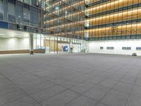 a concrete plaza at night with a metal railing and a building in the background at night