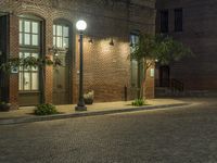 an empty parking lot at night with some planters in pots next to it and two lighted street lamps