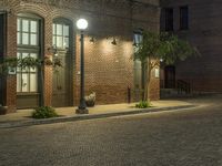 an empty parking lot at night with some planters in pots next to it and two lighted street lamps