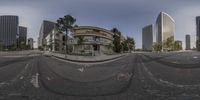 a wide angle picture shows the reflection of a city in the street of a fish eye view