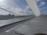 the reflection of a building is seen on the glass wall of a parking garage with its doors open