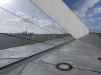 the reflection of a building is seen on the glass wall of a parking garage with its doors open