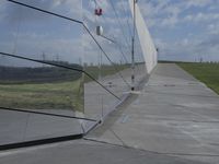 the reflection of a building is seen on the glass wall of a parking garage with its doors open