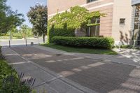 a large brick building sitting next to a lush green tree filled area of grass,