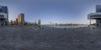 a 360 - camera photograph of a large city with a river and bridge in the background