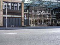 the entrance to an office building along a street is shown here, and it appears to be made of glass