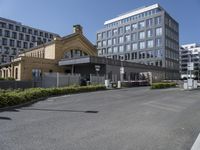 the building is surrounded by two very large buildings on the other side of the road