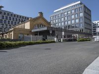 the building is surrounded by two very large buildings on the other side of the road