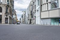 a person is skateboarding down a street with an old building on the side of the road