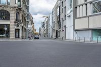 a person is skateboarding down a street with an old building on the side of the road