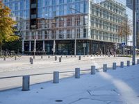 an empty sidewalk with a few buildings in the background and snow on the ground,