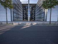 the office building is next to the trees near the sidewalk and walkways with trees