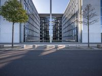 the office building is next to the trees near the sidewalk and walkways with trees
