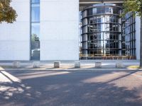 the office building is next to the trees near the sidewalk and walkways with trees