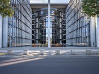the office building is next to the trees near the sidewalk and walkways with trees