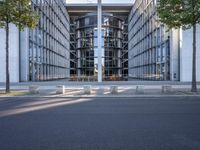 the office building is next to the trees near the sidewalk and walkways with trees