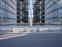 the office building is next to the trees near the sidewalk and walkways with trees