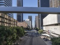 a view of some cars on a road in the city with buildings and trees on either side