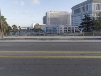 an empty street is lined with tall buildings and trees in the background, next to an orange fire hydrant