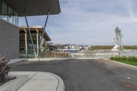 an empty road runs by buildings and water way that appears to be a bridge in a city