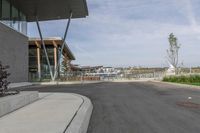 an empty road runs by buildings and water way that appears to be a bridge in a city