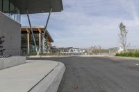 an empty road runs by buildings and water way that appears to be a bridge in a city