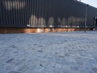 a brick building with glass windows and sidewalk leading to it and a black fire hydrant