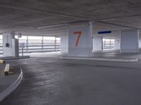 an empty parking garage with two numbered spaces in front of it on one side of the road