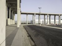 a picture of a very long building in the middle of nowhere with concrete structures and a parking lot in the background