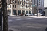 a car stopped at a red light with other vehicles and a man crossing the street