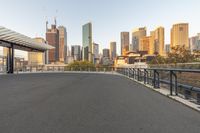 a road in front of a very tall city with a sky scraper on the side of it