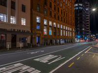 a man walking through an empty street in front of a building at night, with stop sign painted on the road