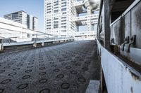 a walkway in front of some skyscrapers and buildings that look like they were in the process of falling