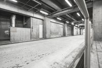 black and white image of empty street next to a building in a mall hallway with concrete walls