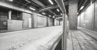 black and white image of empty street next to a building in a mall hallway with concrete walls