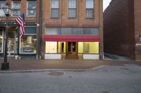 an image of a building with the front doors open and lights on in the entrance