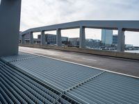 the view of a long highway through a metal grate grid on a city street