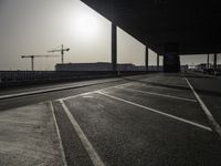 a view of a construction site with traffic lights in the middle of the road under an overpass