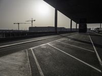 a view of a construction site with traffic lights in the middle of the road under an overpass