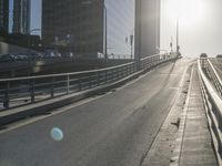 a road in the middle of a city with the sun setting on it's horizon