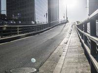 a road in the middle of a city with the sun setting on it's horizon