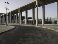 an empty road lined with lots of pillars and pillars are on either side of the building