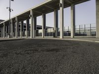 an empty road lined with lots of pillars and pillars are on either side of the building