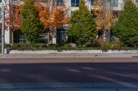 an intersection with a fire hydrant and trees in the background and a building in the foreground