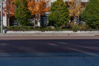 an intersection with a fire hydrant and trees in the background and a building in the foreground