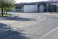 a road with cars and two signs in front of an airport with trees on either side