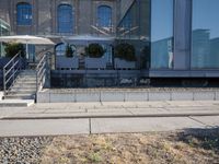 the train station is covered in graffiti outside the building, with people on the walkway